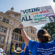 People display signs during the Georgetown to Austin March for Democracy rally on July 31, 2021 in Austin, Texas. Texas activists and demonstrators rallied at the Texas state Capitol after completing a 27-mile long march, from Georgetown to Austin, demanding federal action on voting rights legislation.